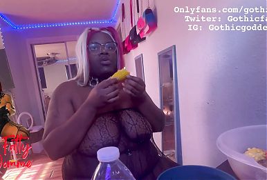 Ebony BBW stuffs her face while she is topless